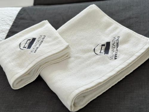 ein Paar weiße Handtücher auf dem Bett in der Unterkunft Villa Magdalena apartments & rooms in Maribor