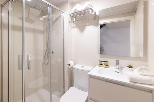 y baño con ducha, aseo y lavamanos. en DormForYou Alameda 12 Apartment, en Valencia