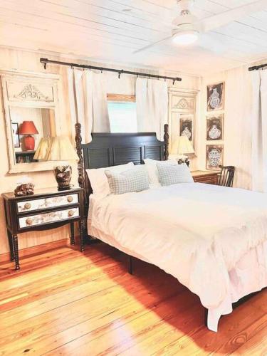 a bedroom with a large white bed and a table at Humble Bee Cottage-Cullman in Hanceville