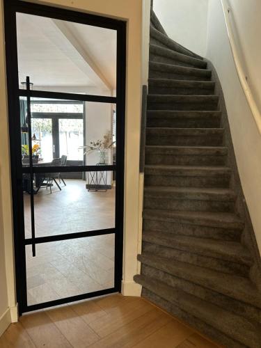 a staircase with a glass door leading to a dining room at High Street Haven in Eindhoven
