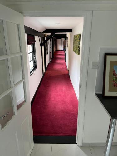 a hallway with a red carpet in a house at Yu’s Guest House in Sevenoaks