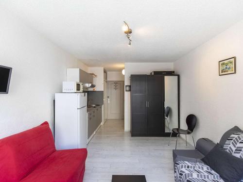 ein Wohnzimmer mit einem roten Sofa und einem Kühlschrank in der Unterkunft Studio Gourette, 1 pièce, 3 personnes - FR-1-400-12 in Gourette