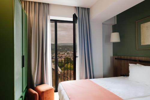 a bedroom with a bed and a window with a view at Hotel 21 in Tbilisi City