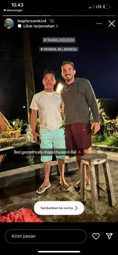 a man and a woman standing next to a bench at Triangle House and hot spring in Kintamani