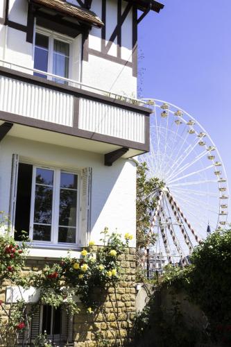 a ferris wheel in front of a house at La Villa Les Mots Passants in Cabourg