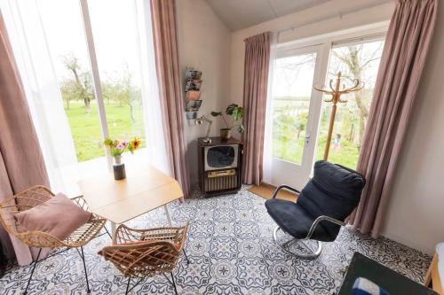 a living room with a table and chairs at De Boterhal - vakantiehuisje op natuurboerderij in Hem
