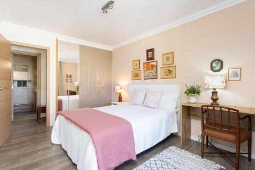 a bedroom with a large white bed and a desk at Apartamento Atlanta in Puerto de la Cruz