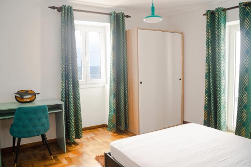 a bedroom with a bed and a desk and a chair at Beach front flats in São Vicente