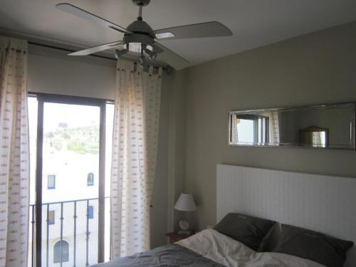 マニルバにあるMarina Duquesa apartemento 2110のベッドルーム1室(天井ファン、窓付)