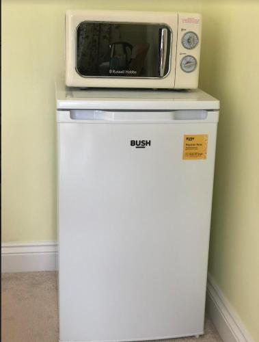 a microwave sitting on top of a refrigerator at Brindles in Sissinghurst