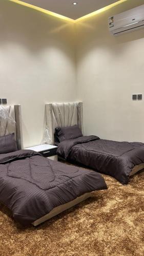2 Betten nebeneinander in einem Zimmer in der Unterkunft شالية الموج الازرق قسمين in Hafar Al-Batin
