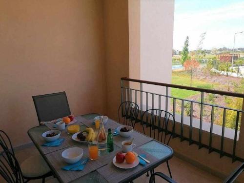a table with plates of food on top of a balcony at Gardens Side By FHR piscina, parking in Quarteira