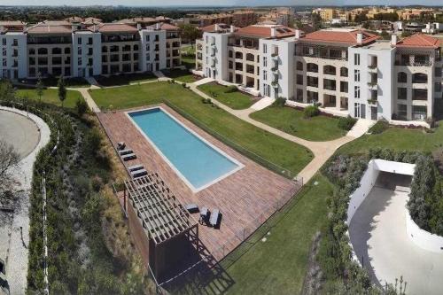 an aerial view of an apartment complex with a swimming pool at Gardens Side By FHR piscina, parking in Quarteira