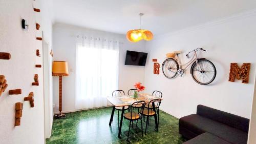 uma sala de jantar com uma mesa e uma bicicleta na parede em THE ROOM - APARTMENT IN LLORET em Lloret de Mar