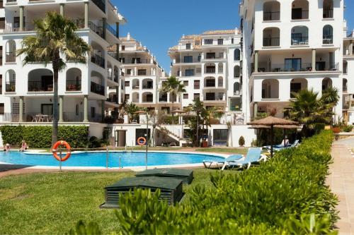 uma piscina em frente a alguns edifícios de apartamentos em Marina Duquesa apartemento 2110 em Manilva