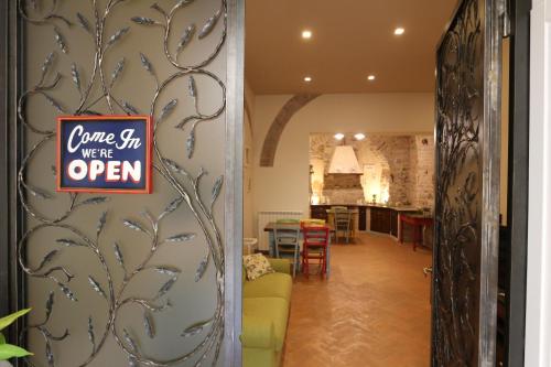 a sign that reads come sit were open on a wall at La Casina Colorata in Assisi
