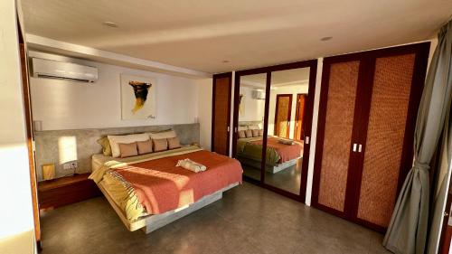 ein Schlafzimmer mit einem großen Bett und einem Spiegel in der Unterkunft Bingin High Tide in Uluwatu