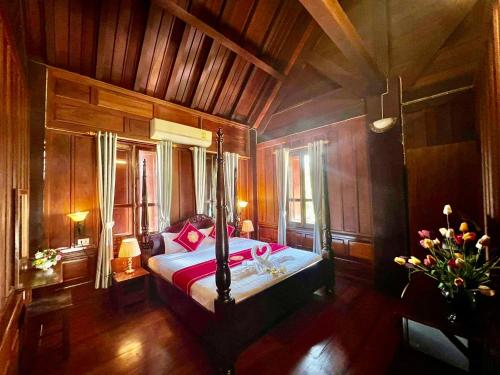 a bedroom with a bed with red pillows on it at Lakhang Thong Hotel in Luang Prabang