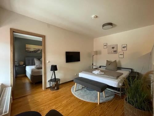 1 dormitorio con cama, sofá y TV en Hotel Sleep and Eat en Hardegsen
