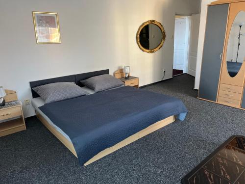 a bedroom with a large bed with a blue blanket at Penzion Ariane in Prague