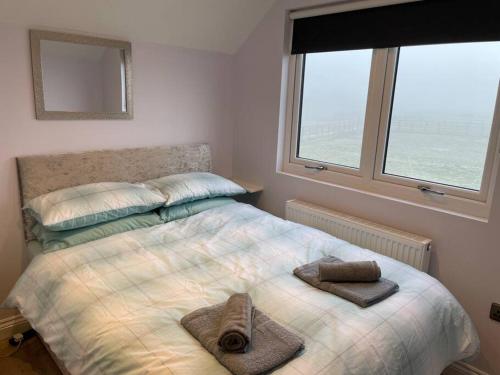 a bedroom with a bed with two towels on it at Hanaverian suit with amazing views of stud farm. in Great Driffield