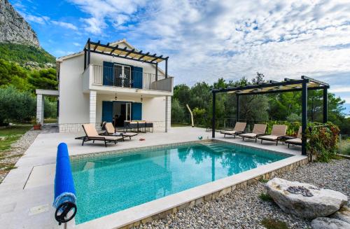 a villa with a pool and a house at Holiday home Blue Stone in Zaostrog