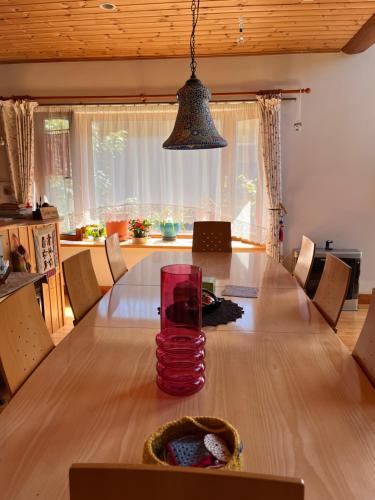 a dining room table with a vase on top of it at Ohisama House in Rusutsu