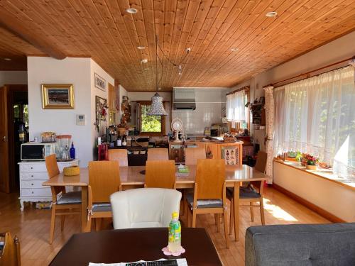 cocina y comedor con mesa y sillas en Ohisama House, en Rusutsu