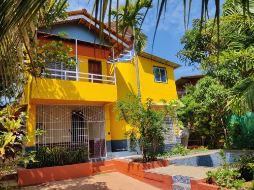 a yellow house with a pool in front of it at Redstone House by Oxystays Hospitality in Ganpatipule