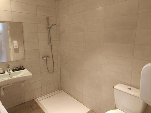 ein Bad mit einer Dusche, einem WC und einem Waschbecken in der Unterkunft Logis Hotel La Bergerie in Saint-Pierre-Lafeuille