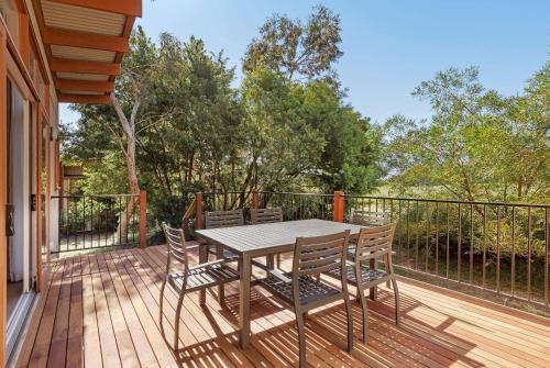 a wooden deck with a table and chairs on it at Ramada Resort by Wyndham Phillip Island in Cowes