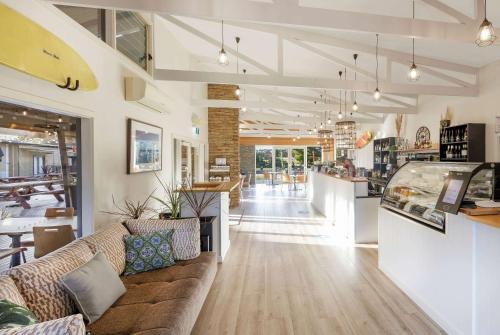 a living room with a couch and a bar at Ramada Resort by Wyndham Phillip Island in Cowes