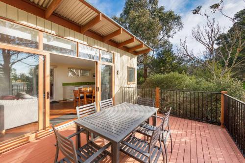 a patio with a table and chairs on a deck at Ramada Resort by Wyndham Phillip Island in Cowes