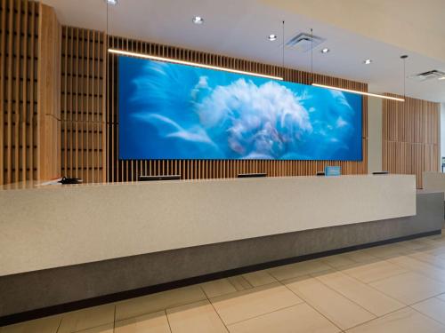 a large flat screen tv on a wall in a lobby at Hilton Pensacola Beach in Pensacola Beach