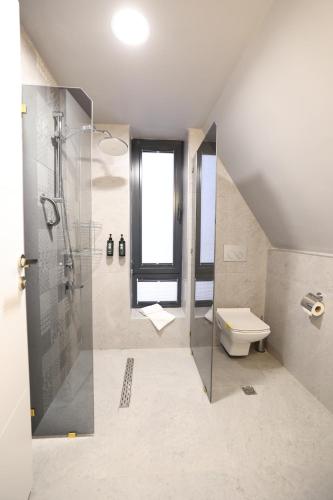 a bathroom with a shower and a toilet at In The Garden Ilıca Thermal Resort Hotel & Aqua Park in Erzurum