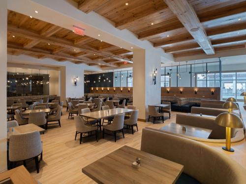 un ristorante con soffitti e tavoli in legno e sedie di Hilton Pensacola Beach a Pensacola Beach