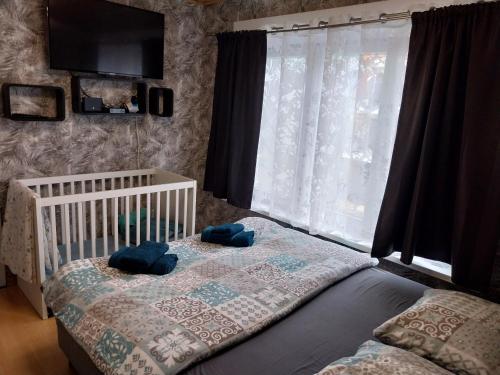 a bedroom with a crib and a large window at @Zakibelle in Bredene