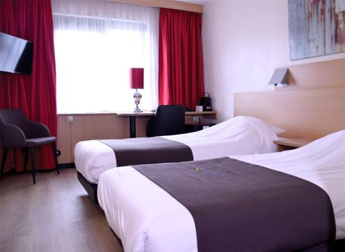 2 Betten in einem Hotelzimmer mit roten Vorhängen in der Unterkunft Bastion Hotel Leiden Voorschoten in Leiden