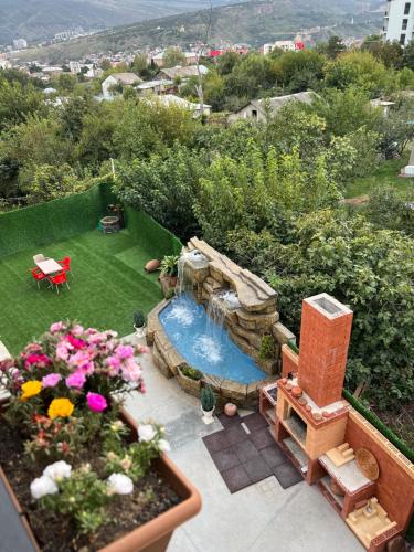 villa with beautiful view 2 في تبليسي: اطلالة من الجو على حديقة خلفية بها مسبح وزهور