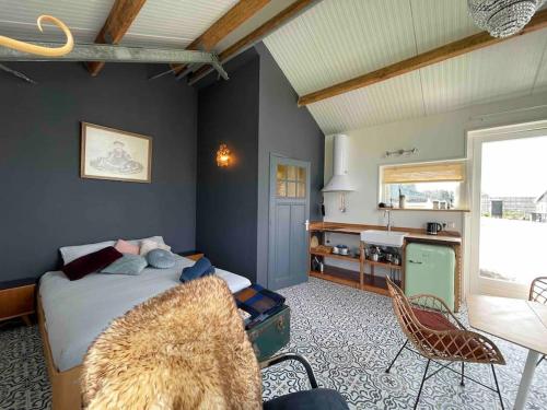 a bedroom with a bed and a table and chairs at Groepsaccommodatie op natuurboerderij Huize Blokland in Hem