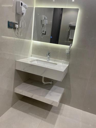 een badkamer met een witte wastafel en een spiegel bij وسن الشرق in Dammam