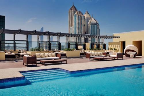 a pool on the roof of a building with a city at Southern Sun Abu Dhabi in Abu Dhabi