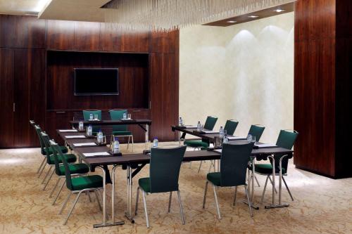 a conference room with long tables and green chairs at Southern Sun Abu Dhabi in Abu Dhabi