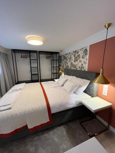 a bedroom with a large bed and a table at Central Gallery Apartment in Debrecen