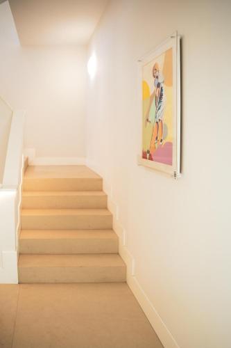 a staircase in a room with a painting of a woman at CISNES PALACE in Sanlúcar de Barrameda