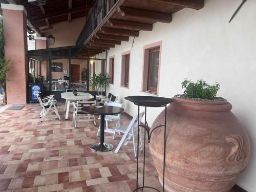 a patio with a large vase and tables and chairs at Villa San Biagio Residence in Mason Vicentino