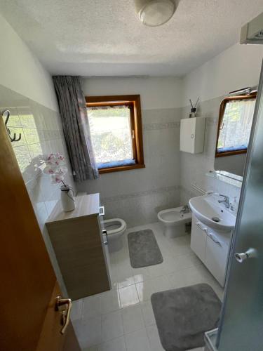 La salle de bains est pourvue d'un lavabo et de toilettes. dans l'établissement Apartman Anda, à Cavalese