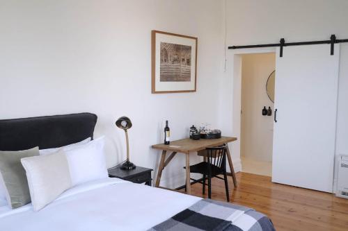 1 dormitorio con cama, mesa y escritorio en Flash Jacks of Gundagai, en Gundagai