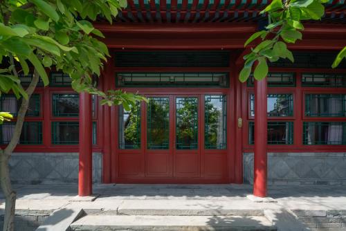 a red door of a building with windows at Beijing Heyuan Courtyard Hotel (Forbidden City) in Beijing