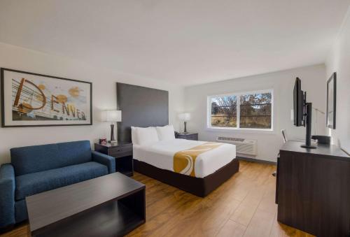 Quality Inn & Suites Castle Rock SW Denver في كاسل روك: غرفه فندقيه بسرير واريكه